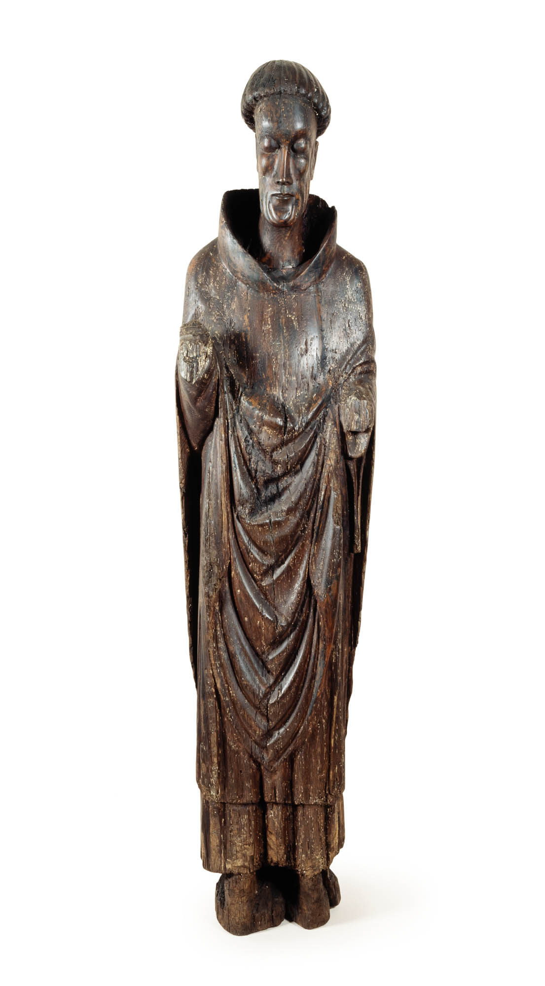 Dark wooden statue of gaunt bearded saint in flowing robes that is missing both arms.